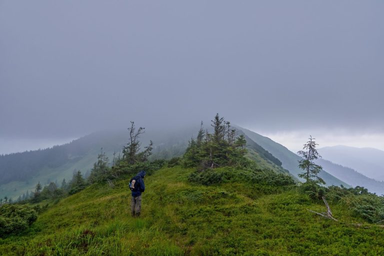 Hiker in thick fog on a mountain ridge