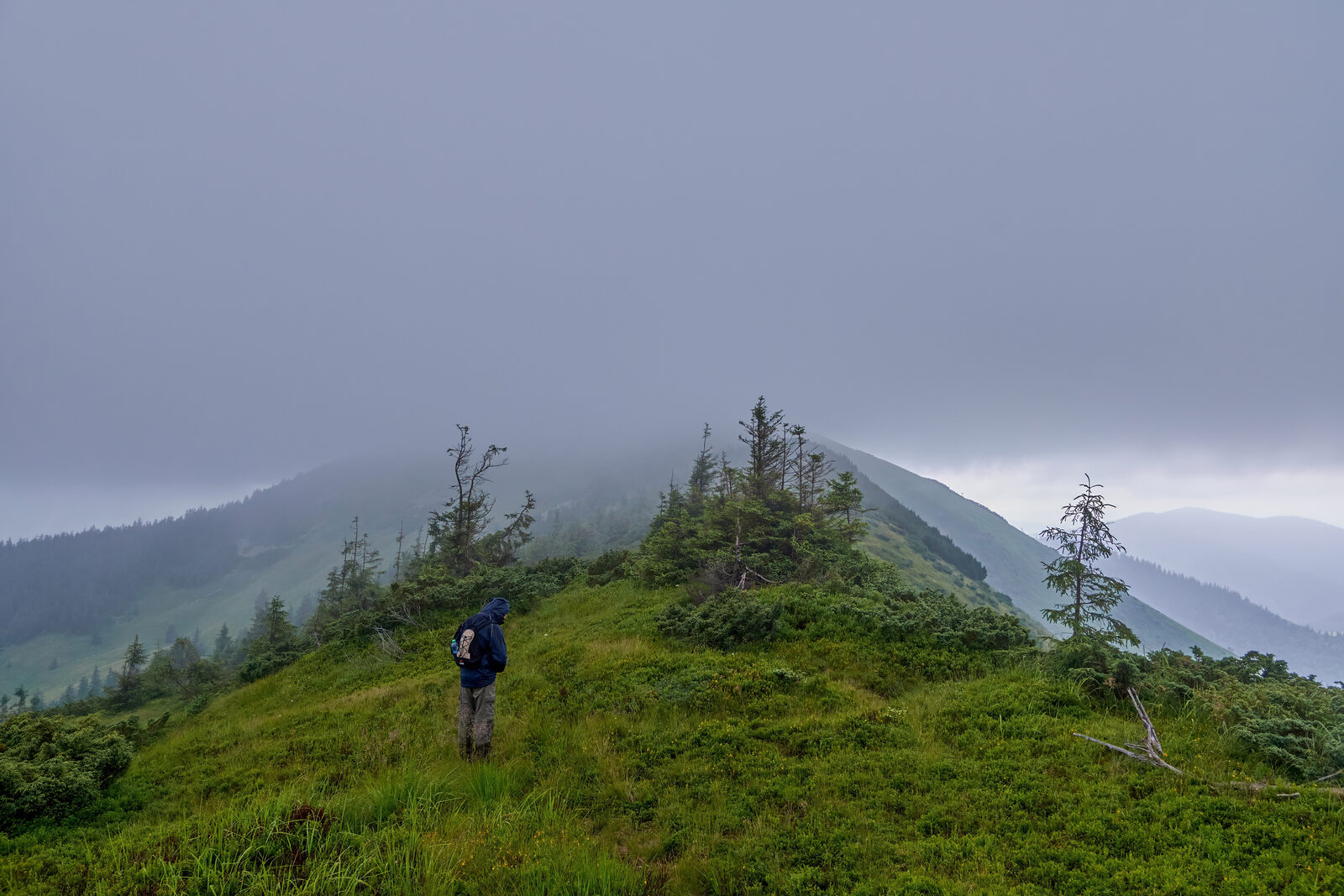 Hiker in thick fog on a mountain ridge