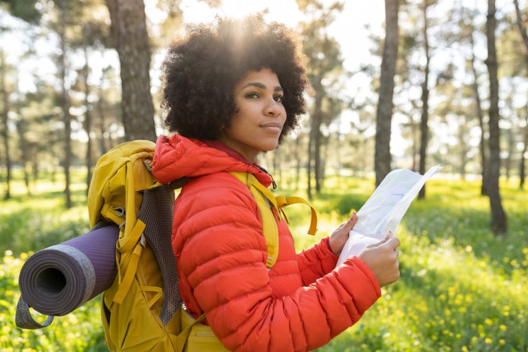Lost hiker pausing to read a map in the forest