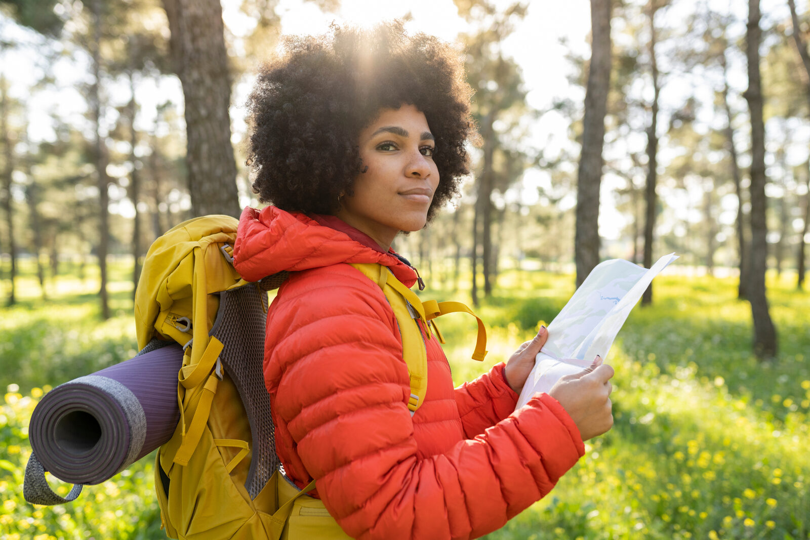 Lost hiker pausing to read a map in the forest