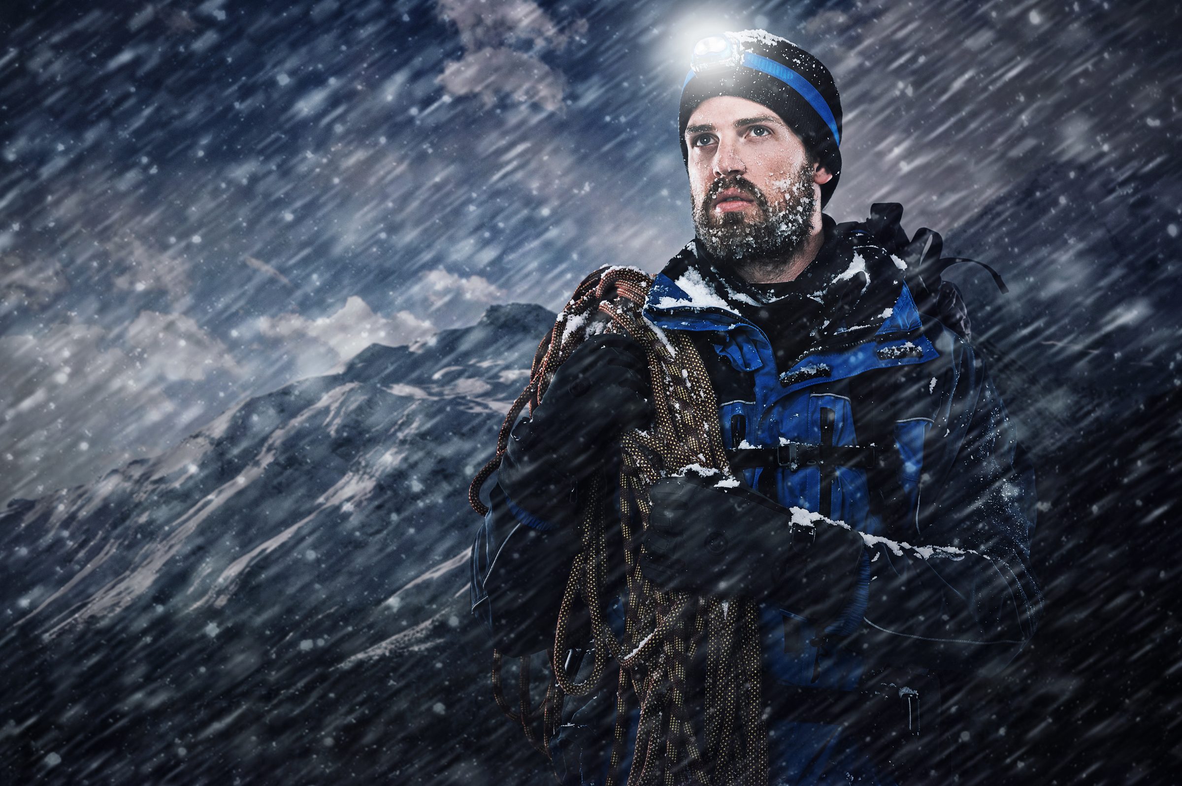 Hiker moving across a high exposed snow-covered ridge in thin air