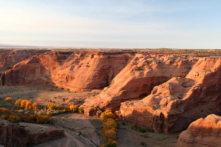Red sandstone walls and cottonwoods in Canyon de Chelly, Arizona